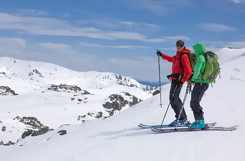 Pair of Skiiers on a snowy mountain peak